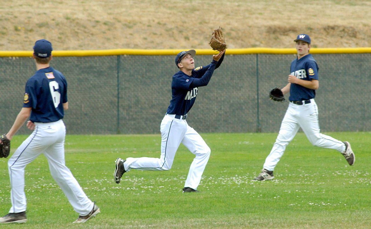 Keith Thorpe/Peninsula Daily News Wilder Junior outfielder Tanner Price, center, gets under an incoming fly while flanked by teammates Wyatt Hall, left, and Timmy Adams in the first game of Saturday’s double-header against Mount Vernon at Volunteer Field in Port Angeles.