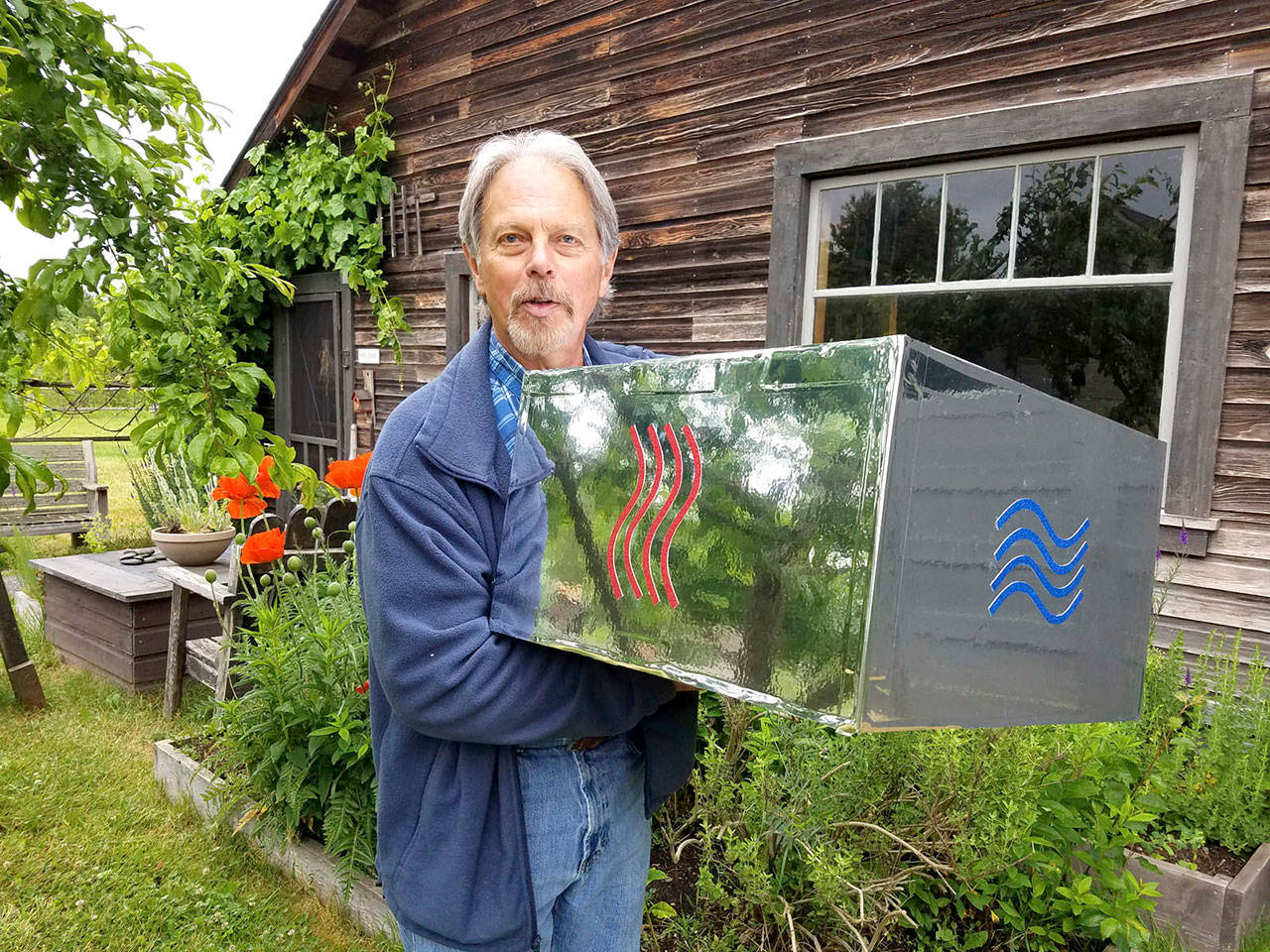Brian Buntain holds a section of the Fifth Element totem pole which will be central to this years Art Jam exhibit at Rock Hollow Farm in Sequim.