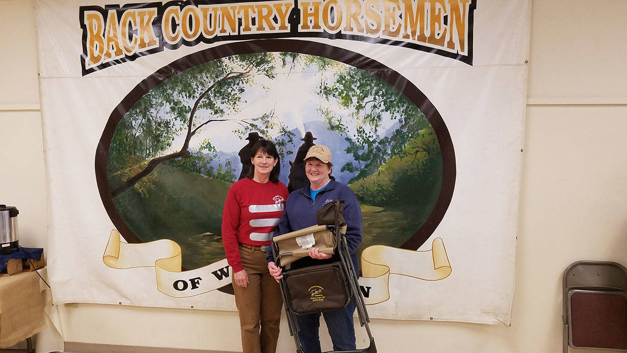 Back Country Horsemen of Washington’s Buckhorn Range Chapter Treasurer Judith Hoyle, right, was honored to receive the Backbone Award at the BCHW annual Rendezvous at Kittas Valley Fairground. The outdoor chair with the BCHW logo and her name embroidered on it was presented by BCHW President Kathy Young. (Bob Hoyle)