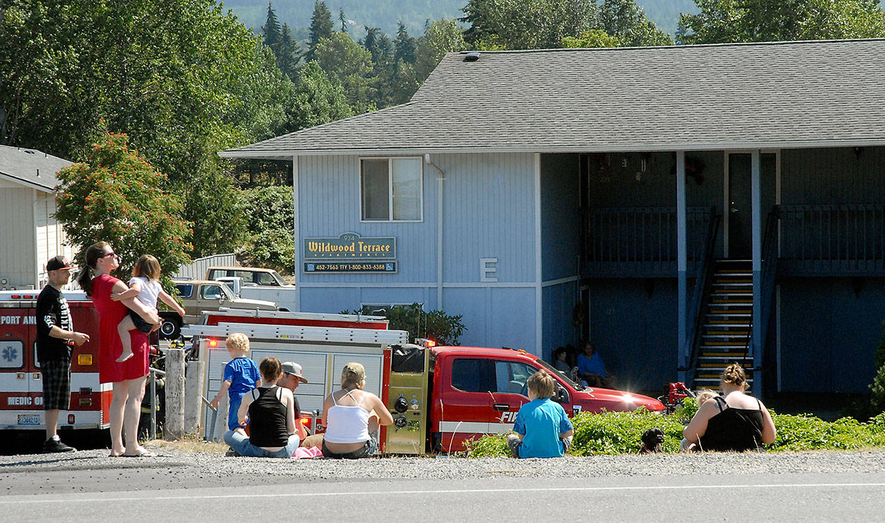 A group of residents of Wildwood Terrace Apartments, 934 W. Lauridsen Blvd., wait along the street after a propane gas leak forced the evacuation of about 40 people on Tuesday afternoon in Port Angeles. (Keith Thorpe/Peninsula Daily News)
