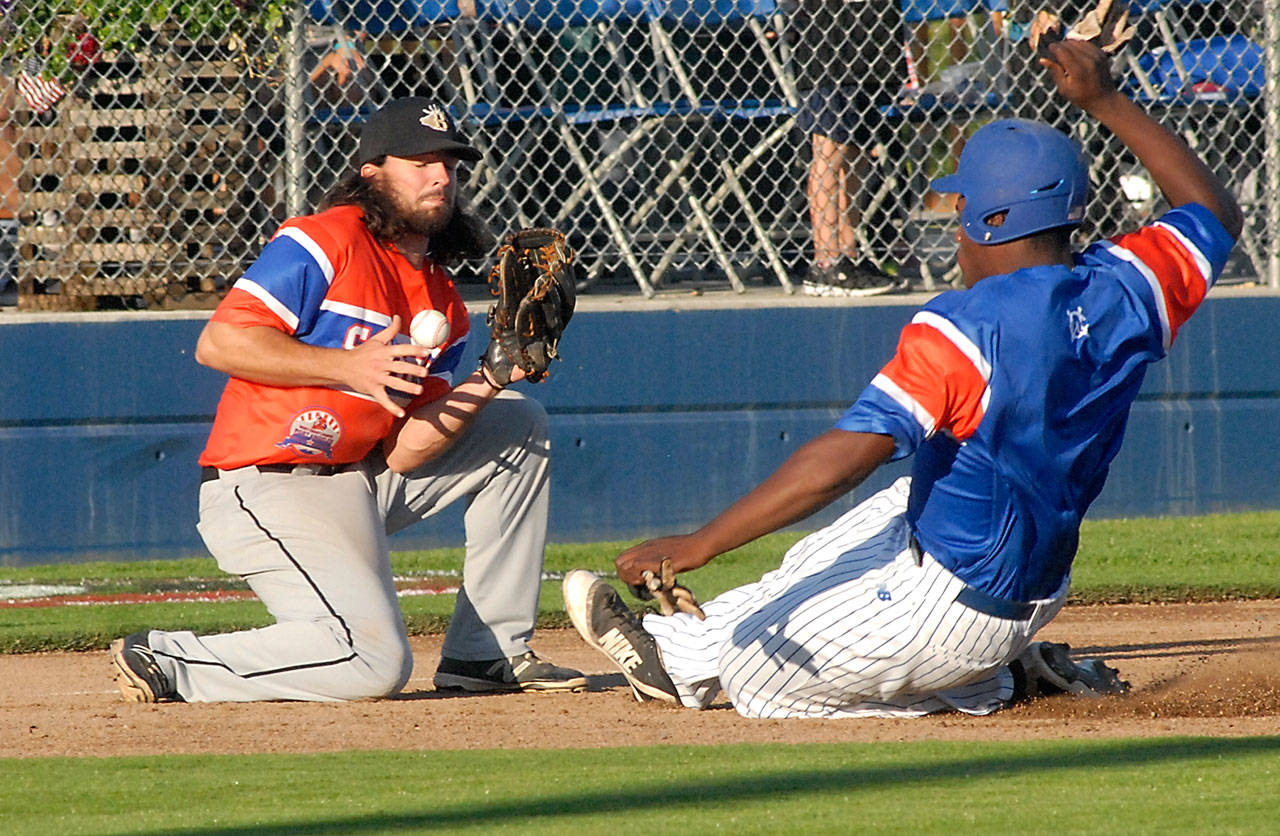 Keith Thorpe/Peninsula Daily News Lefties’ Ron Brown, right, slides towards third base as Bend’s Collin Runge fumbles the ball during the West Coast League All-Star Game at Civic Field.