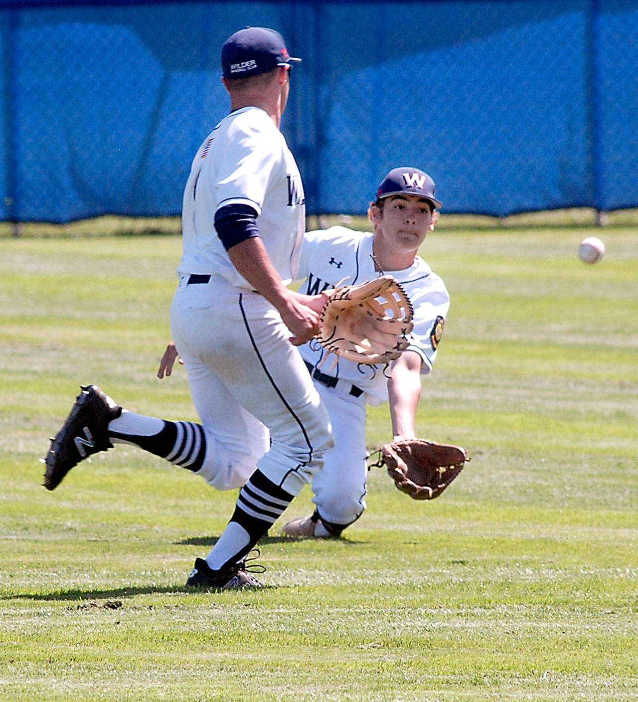Keith Thorpe/Peninsula Daily News Wilder center fielder Tyler Bowen, right, reaches for a fly ball as left fielder Carson Jackson looks on during the first game of a double header against Lakeside Recovery on Wednesday at Port Angeles Civic Field.
