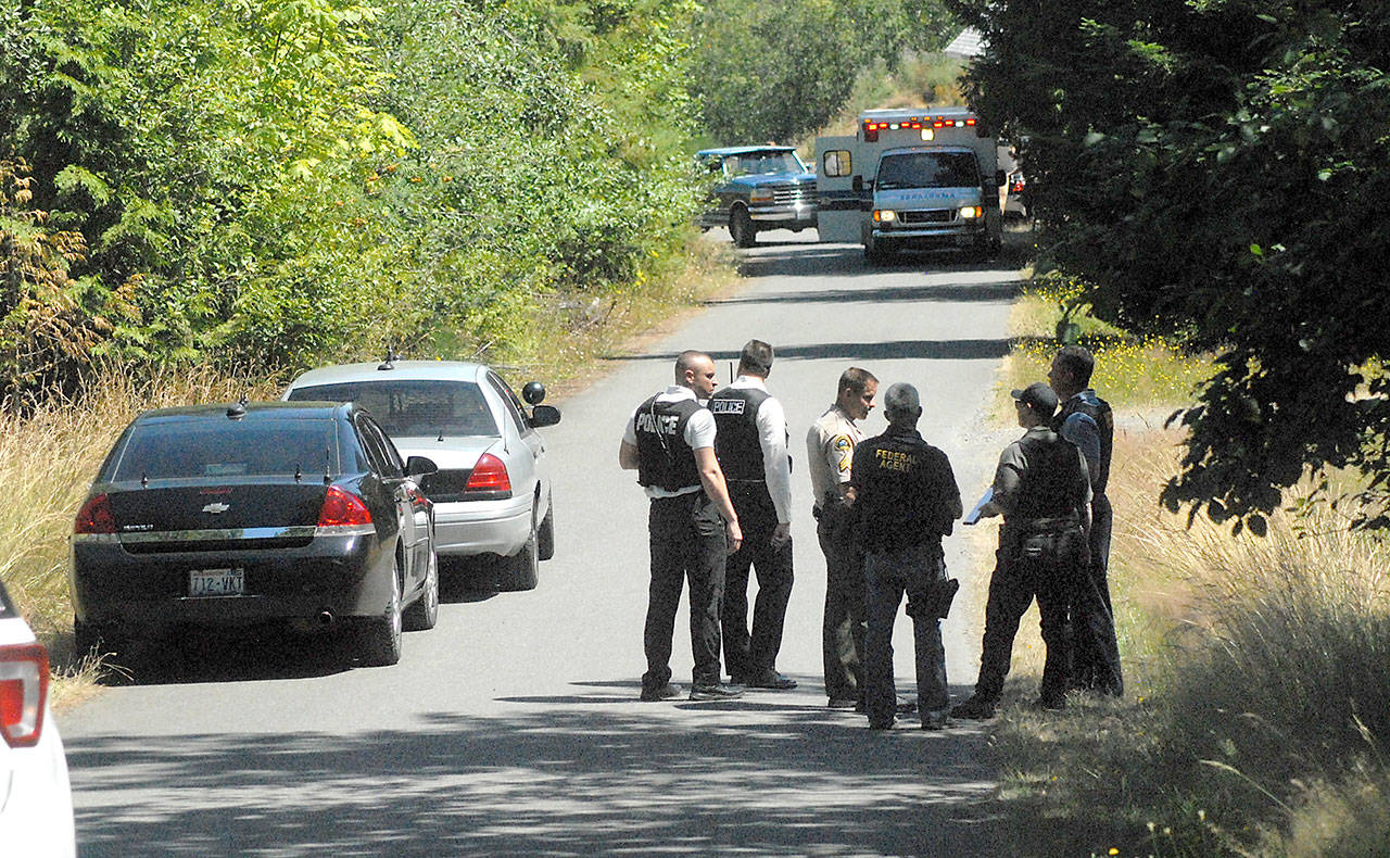 Law enforcement agents gather at the scene where a man opened fire on his neighbor’s house on Mountain Home Road in the Mount Pleasant area southeast of Port Angeles. (Keith Thorpe/Peninsula Daily News)