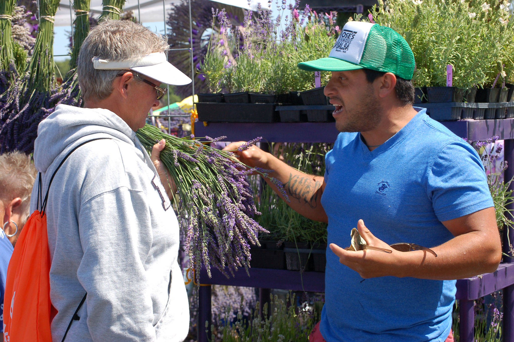 Loretta Spencer from Hoodsport chats with Juan Gonzalez of Meli’s Lavender Farm about lavender at the Sequim Lavender Festival Street Fair at Carrie Blake Park. (Erin Hawkins/Olympic Peninsula News Group)