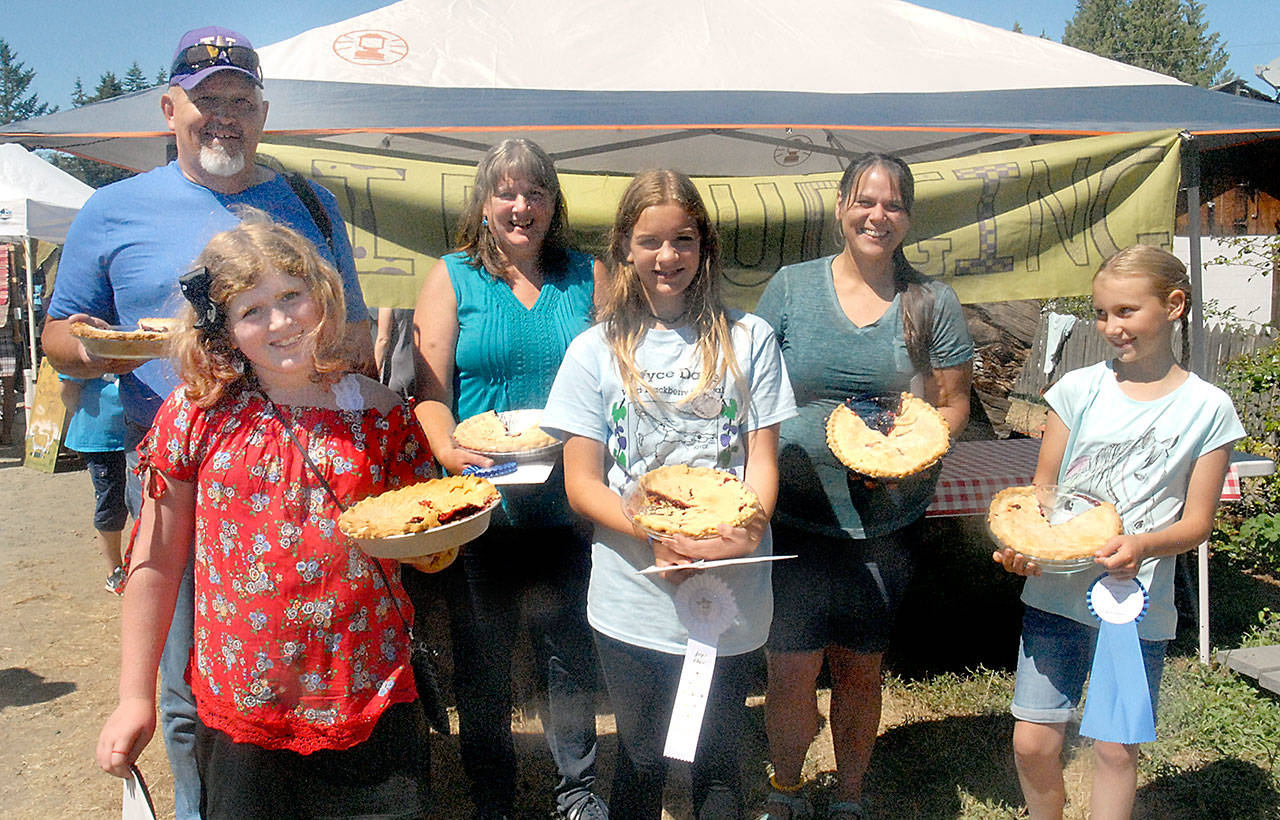 Winners of the Joyce Daze Wild Blackberry Festival pie contest hold their winning pies after judging. Youth winners were, front row from left, Ariana Varholla, 10 of Port Angeles, second place; Lauren Stephens, 12, of Portland, Ore., third place; and Lily Robertson, 10, of Joyce, first place. Adult winners were, back row from left, Chuck Rondeau of Port Angeles, second place; Katy Thompson of Joyce, first place; and Aimee Durgan of Port Orchard, third place. Judges sampled 16 pies in the adult category and four in the youth competition. (Keith Thorpe/Peninsula Daily News)