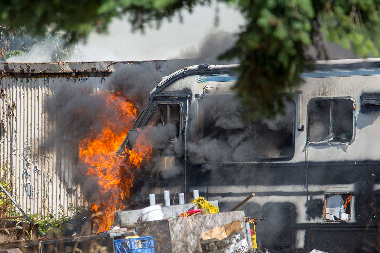 Fire and smoke shoot out of an RV on the 2300 block of East Fifth Avenue on Sunday afternoon. Firefighters were unsure of the cause Sunday. (Jesse Major/Peninsula Daily News)