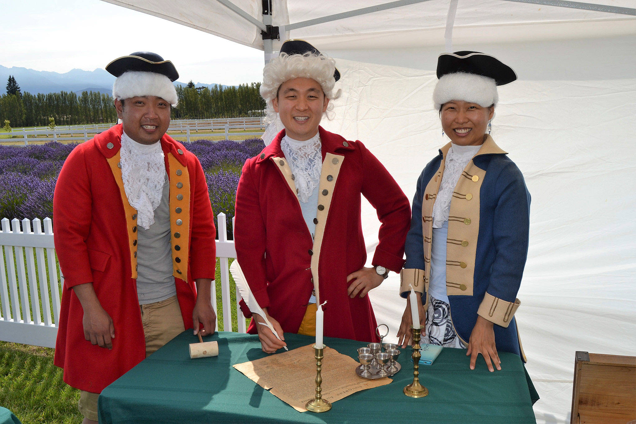 Friends from Seattle, from left, Peter Cher, Jung Jim and Jin Lim dress the part for a photo-op as they prepare to sign the Declaration of Independence at the 2017 Northwest Colonial Festival. Visitors also can dress in colonial clothes at this year’s event this weekend. (Matthew Nash/Olympic Peninsula News Group)