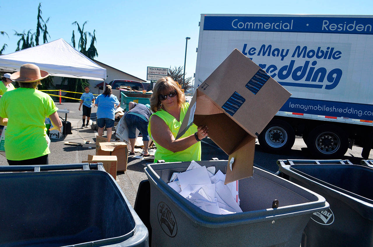 Christy Francis with Castell Insurance dumps documents for shredding at Castell Insurance’s annual shred event.