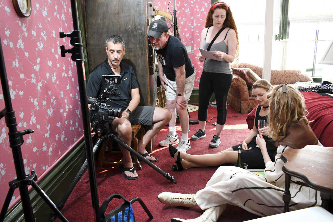 Port Townsend’s Palace Hotel serves as the set for the independent film “A Twist of Time.” Kit Wilson, producer and writer, takes a look at a just-filmed scene with Craig Allen, director of photography. Assistant Director Ronee Collins talks with stars Nicole Moriarty and Eryn Rea. The film’s actors and crew were in town for two days and will finish production in Seattle. (Jeannie McMacken/Peninsula Daily News)