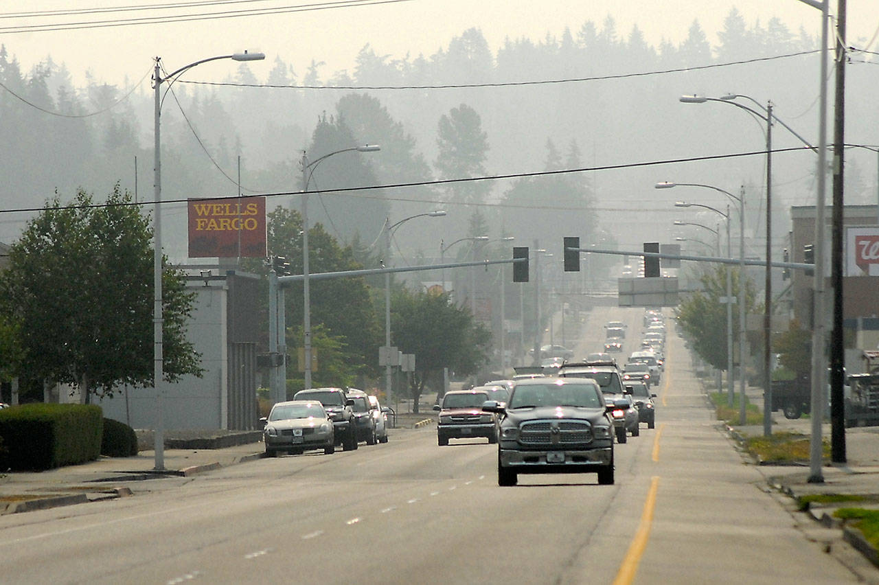 Wildfire smoke creates a blanket of haze over Port Angeles on Wednesday as cars make their way down Front Street. (Keith Thorpe/Peninsula Daily News)