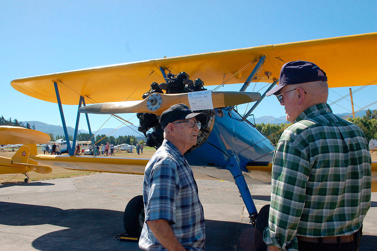 At last year’s Olympic Peninsula Air Affaire and Fly-In, John Denny of Seattle, left, chats with Patrick Nolan of Sequim about a 1942 PT-17 Stearman restored as a World War II trainer plane owned by the Port Townsend Aero Museum. (Erin Hawkins/Olympic Peninsula News Group)