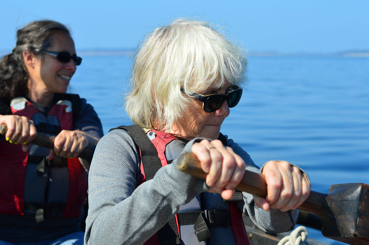 Lisa Greenfield, foreground, and Rebecca Katz, both of Port Townsend, combine strengths while rowing the longboat Bear on Friday. (Diane Urbani de la Paz/for Peninsula Daily News)