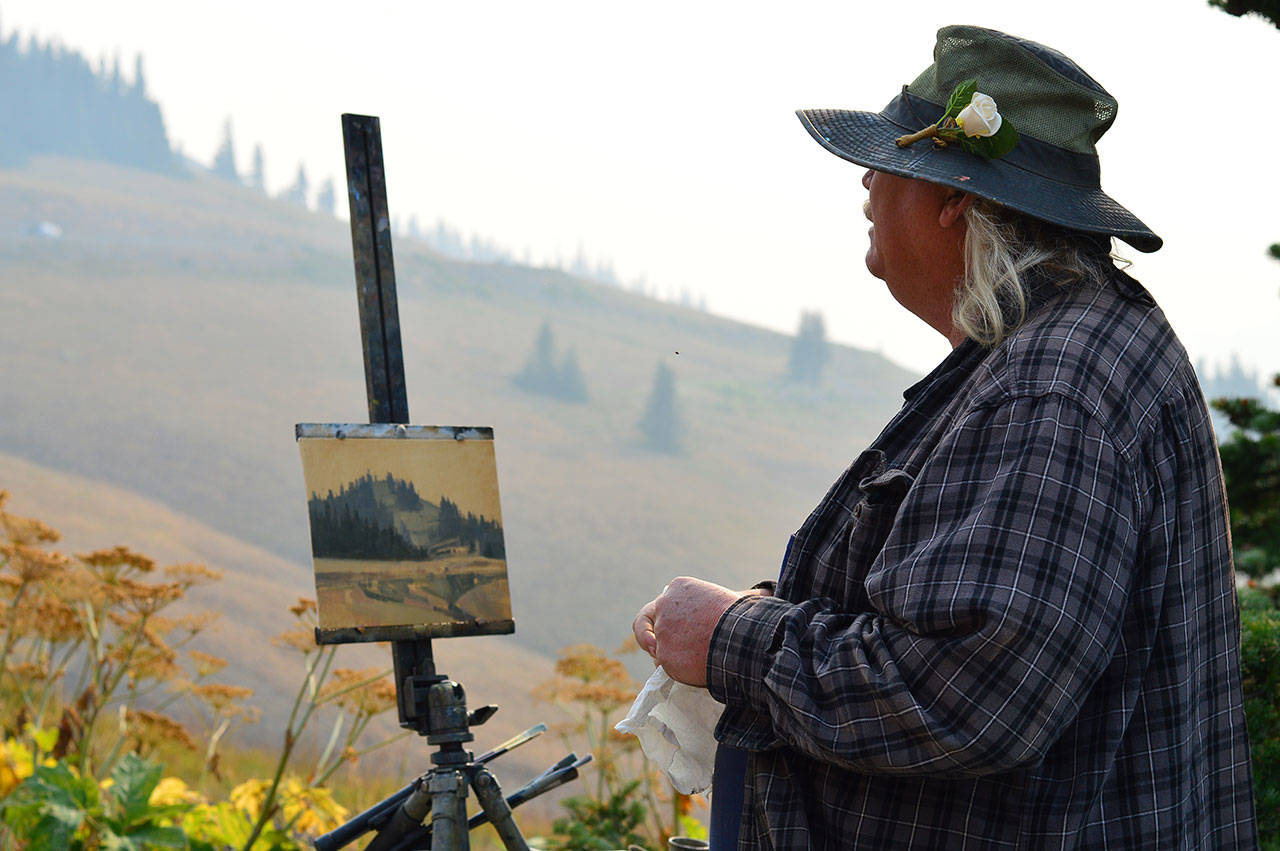 J. Brad Holt, one of the artists involved in this week’s Paint the Peninsula festival, works atop a hazy Hurricane Ridge on Tuesday morning. The Utah-based painter found a deserted Olympic National Park Visitor Center and some unusual colors in the August sky. Holt and 20 other painters from across the country are displaying their plein air works at the Port Angeles Fine Arts Center, 1203 E. Lauridsen Blvd., through Sunday. On Thursday from 6 p.m. to 7:30 p.m., the center will host a free, public awards party for paintings done in Olympic National Park. For information, see &lt;a href="https://www.paintthepeninsula.org/" target="_blank"&gt;www.paintthepeninsula.org&lt;/a&gt;. (Diane Urbani de la Paz/for Peninsula Daily News)