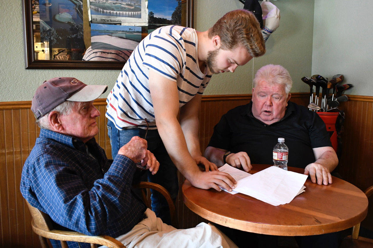 Director Robert Harold, center, goes over a scene with actors Don White, left, and Jack O’Conner. Harold’s short drama “Over the Course of Time” is being filmed at the Port Townsend Golf Club and features local talent. The film wraps up production this week. (Jeannie McMacken/Peninsula Daily News)