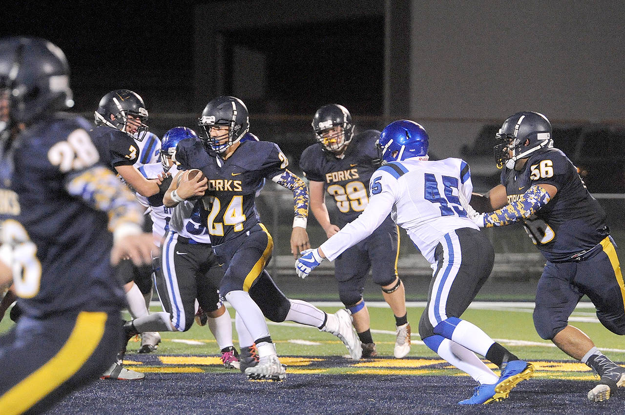 Lonnie Archibald/for Peninsula Daily News Forks Colby Demorest runs with the ball during a game against North Mason last season. Also in on the action for Forks are returners from left, Brett Moody, Caleb Peters and Eden Cisneros.