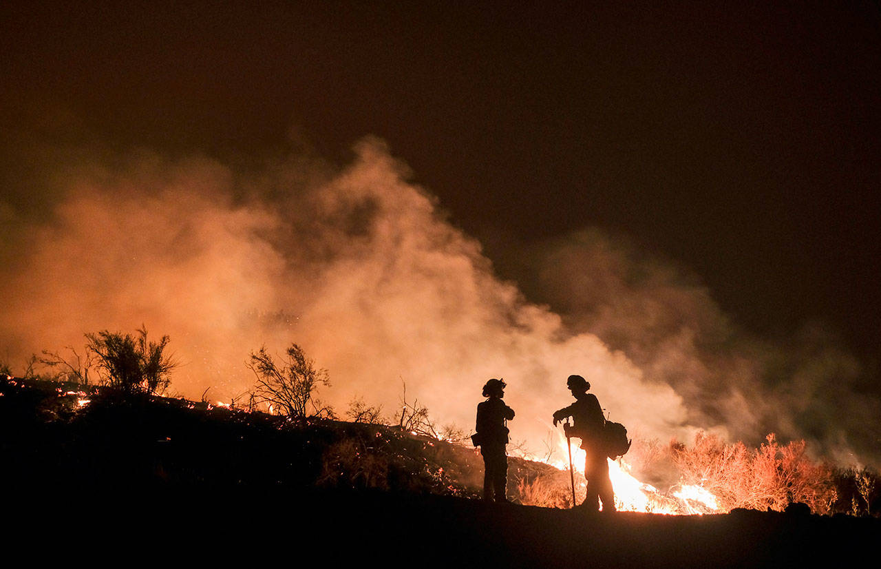Firefighters keep watch over the Holy Fire burning in the Cleveland National Forest in Lake Elsinore, Calif., on Aug. 9. (Ringo H.W. Chiu/The Associated Press)