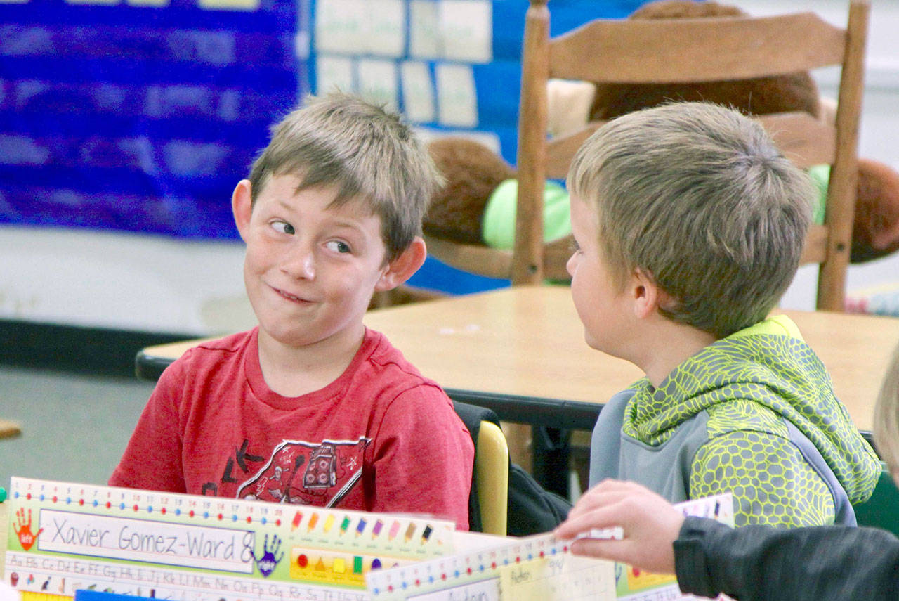Aaron Kalfur, left, eyes new classmate Charlie Parsinen as they await the start of first grade at Hamilton Elementary in Port Angeles on Tuesday. (David Logan/for Peninsula Daily News)
