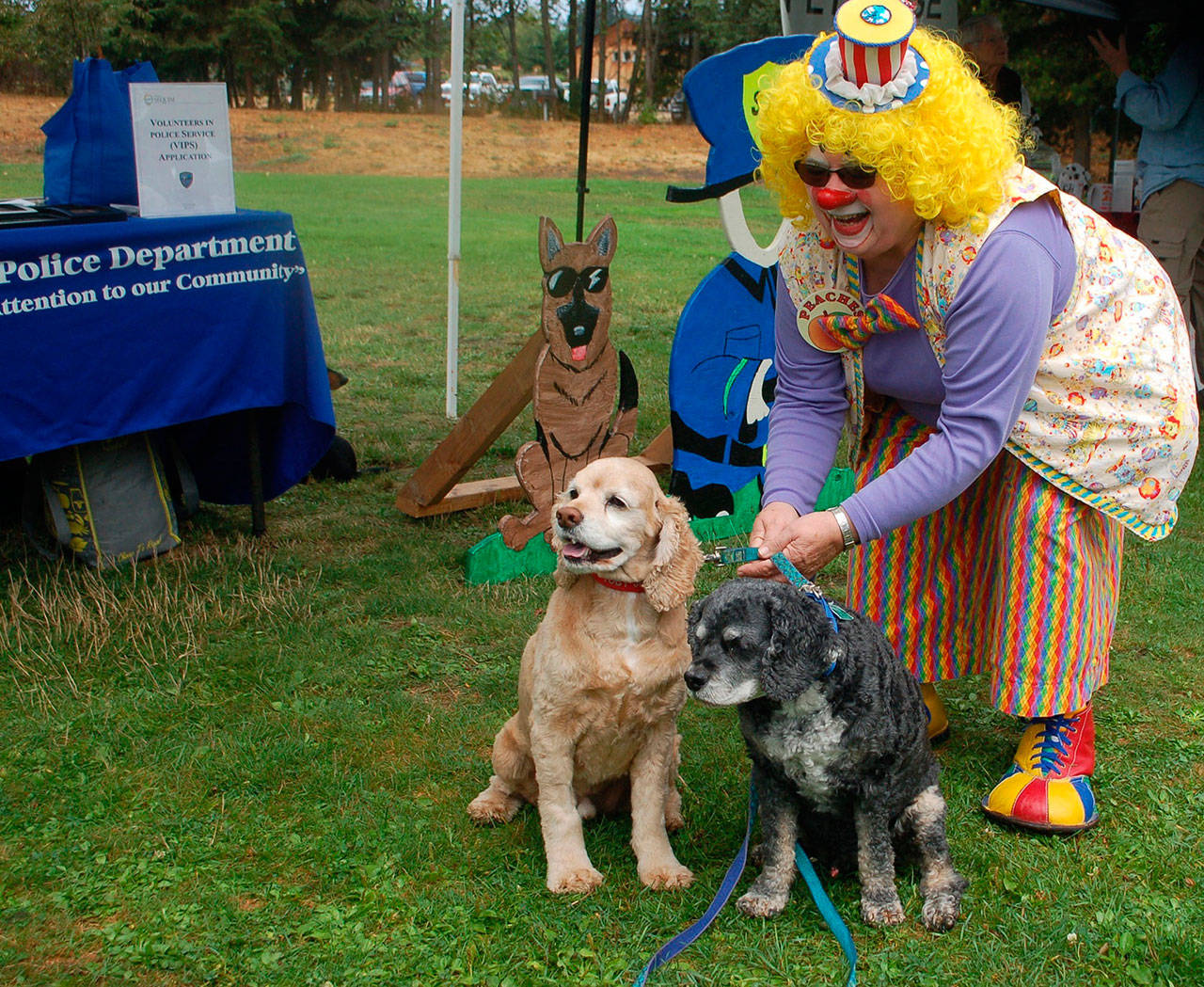 Naomi Foley, also known as “Peaches” the clown, takes a photo with two cockapoos Toby, left, and Barkley at the Sequim Dog Park’s 10th Anniversary celebration at Carrie Blake Community Park in 2017. (Erin Hawkins/Olympic Peninsula News Group)