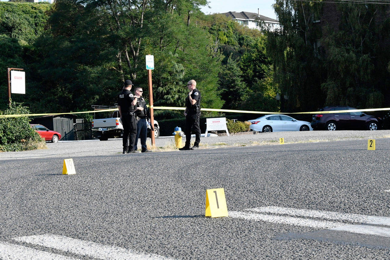 Port Townsend police officers gather evidence at the scene of a stabbing at the corner of Adams and Washington streets Thursday morning. (Jeannie McMacken/Peninsula Daily News)