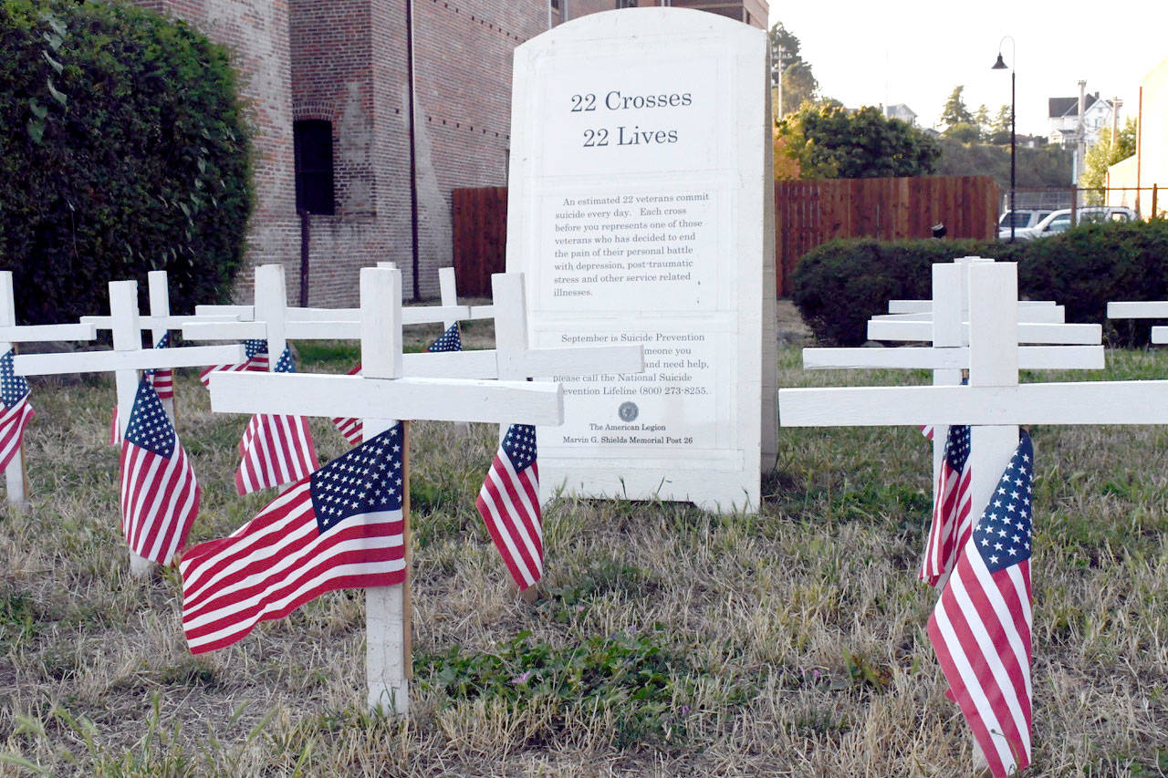 The American Legion Post No. 26 in Port Townsend has a display of 22 American flags and simple white crosses meant to remind viewers that 22 veterans commit suicide every day in the United States. September is National Suicide Prevention Month. (Jeannie McMacken/Peninsula Daily News)