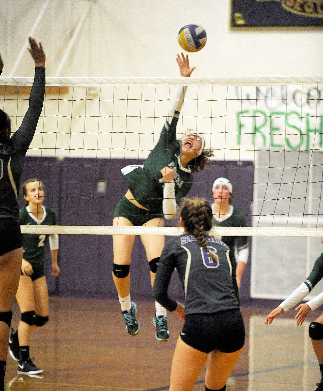 Port Angeles’ Madison Cooke skies high for an attack as Sequim’s Brittany Gale (6) looks to defend the play. Sequim topped the Roughriders in three sets at the teams’ Olympic League opener. Michael Dashiell/Olympic Peninsula News Group