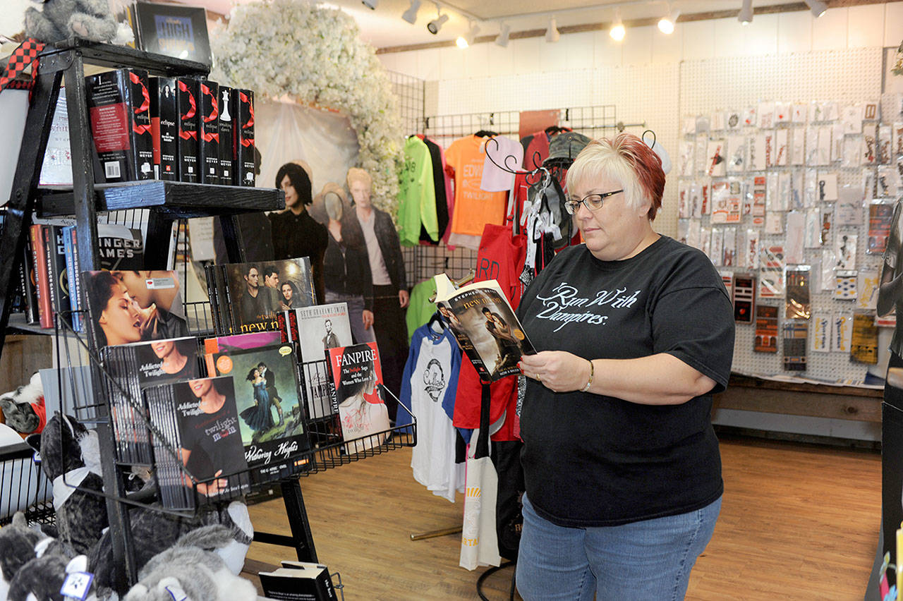 Krista Rush of Spokane looks over some of the Twilight items on display at the Rainforest Art Center in Forks during the 2017 Forever Twilight celebration. (Lonnie Archibald/for Peninsula Daily News)