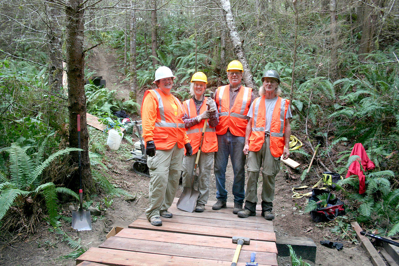Back Country Horsemen Buckhorn Range chapter members Judith Hoyle, left, Helen Shewman, Larry Sammons and Bob Hoyle near completion on a stock-ready puncheon type bridge on a soon to open multi-user trail for mountain bikers, equestrians and hikers in a Jefferson County park located at Beausite Lake Road in Chimacum. (Karen Griffiths/for Peninsula Daily News)