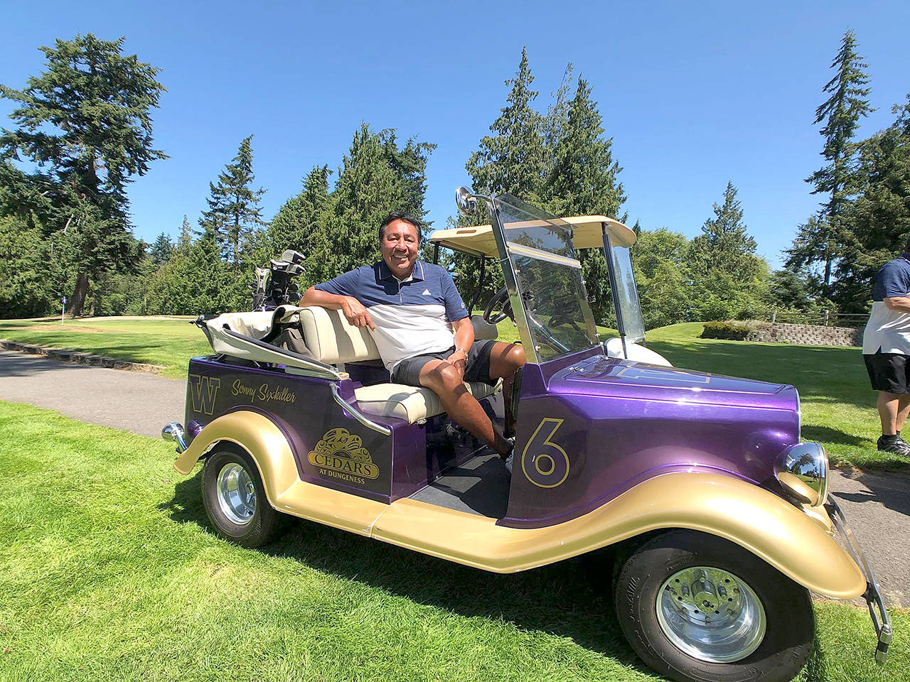 Cedars at Dungeness Washington football legend Sonny Sixkiller sits in a customized UW Football golf cart before the eighth annual Sonny Sixkiller Celebrity Golf Classic in July. The golf cart was among around 50 carts destroyed in a fire at Cedars at Dungeness on Sunday morning.