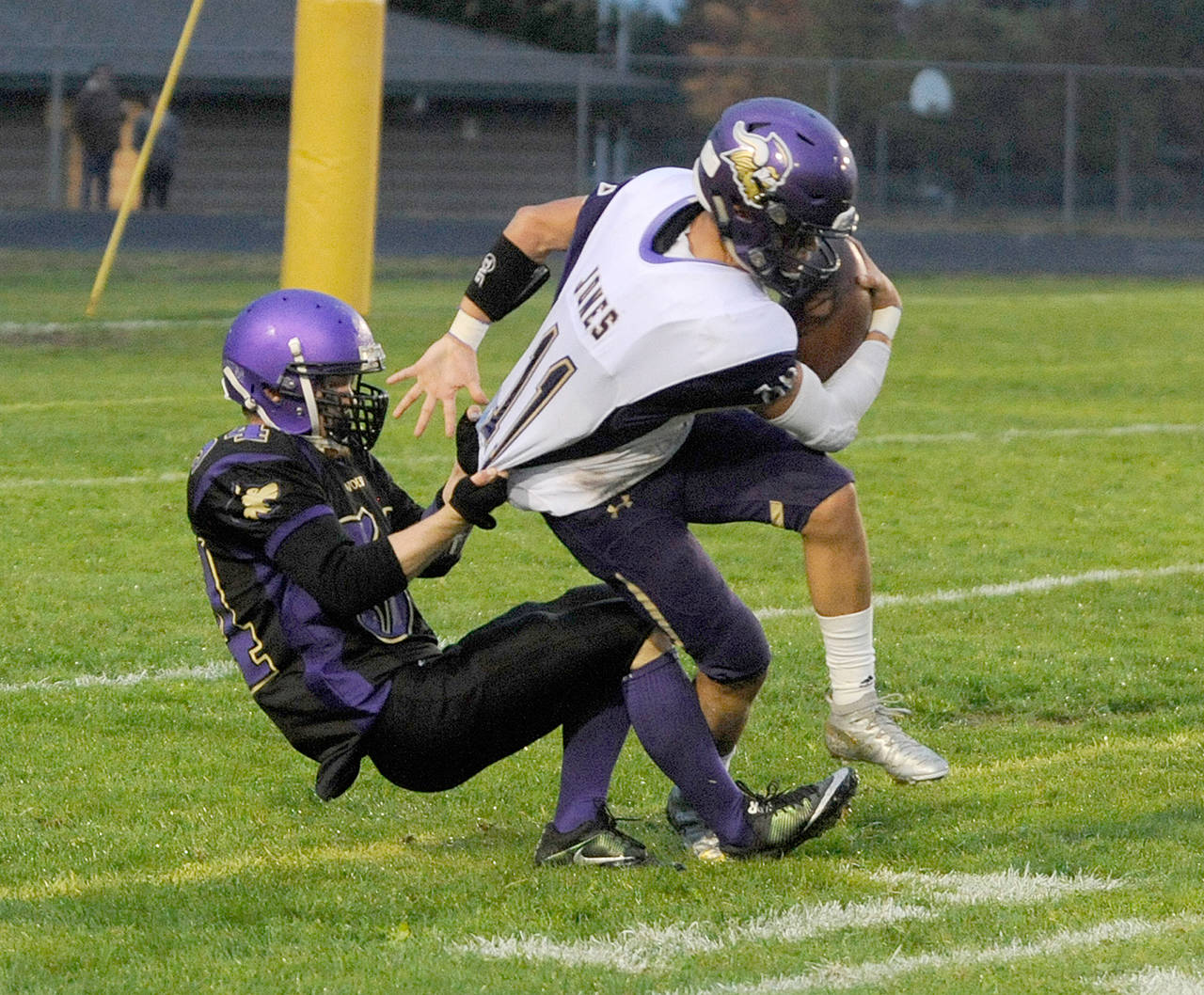 Sequims Ben Cowan, left, drags down North Kitsaps John Jones near the goal line during the Wolves 16-14 upset of the Vikings last Friday.                                Michael Dashiell/Olympic Peninsula News Group
