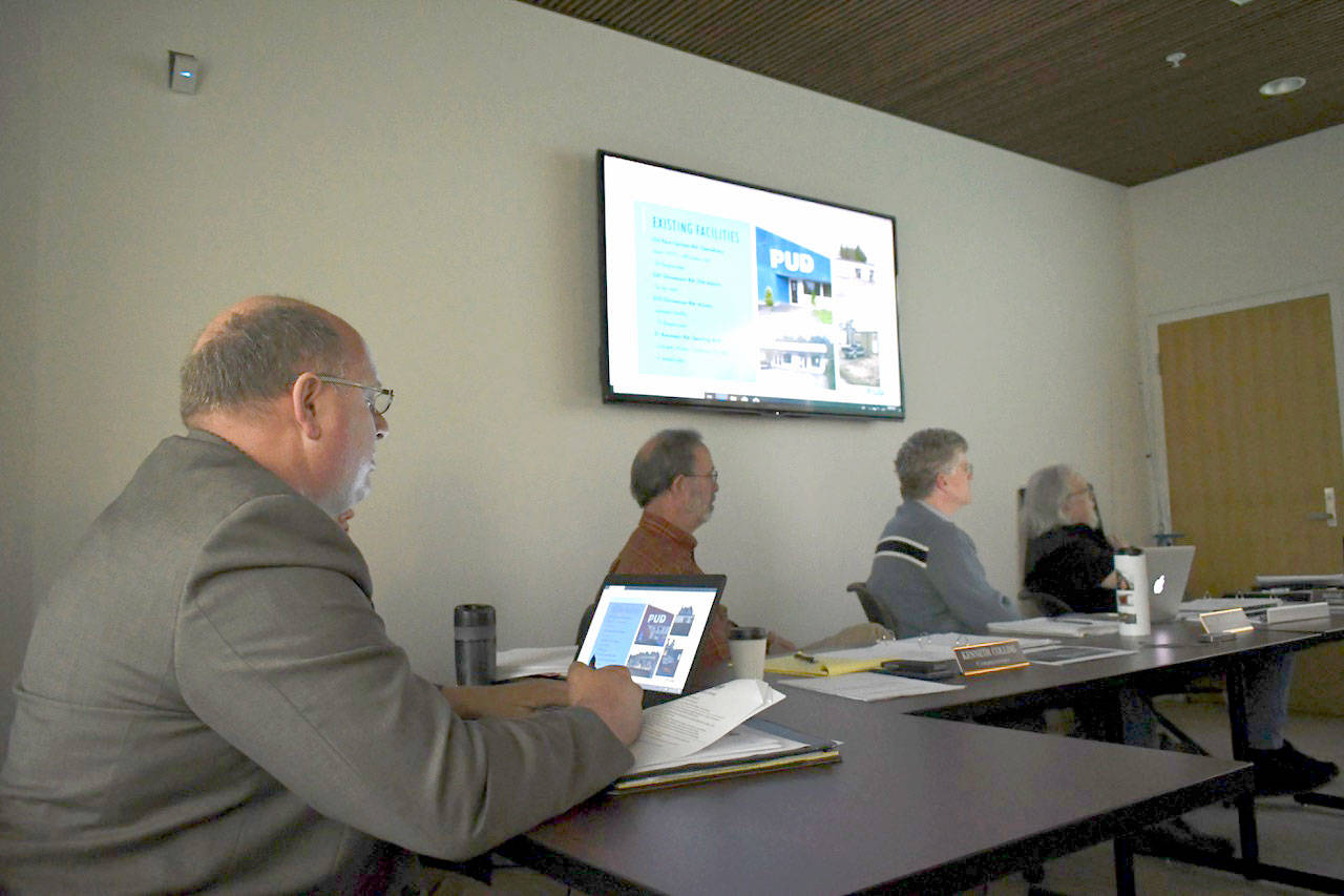Jefferson County PUD General Manager Larry Dunbar, left, makes a presentation about the proposed expansion of the utility’s Port Townsend headquarters during a meeting Tuesday evening. Commissioners Kenneth Collins, Jeff Randall and Wayne King focus in on the details of the facility remodel and expansion. (Jeannie McMacken/Peninsula Daily News)