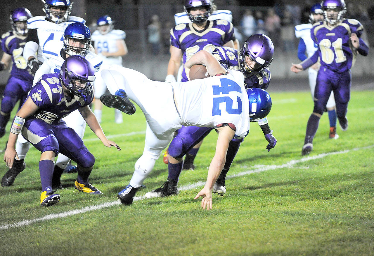 Michael Dashiell/Olympic Peninsula News Group Sequim’s Taig Wiker (15) drops North Mason’s Ryan Smelcer for a loss on a 4th and inches play early in the Wolves’ 20-0 win.