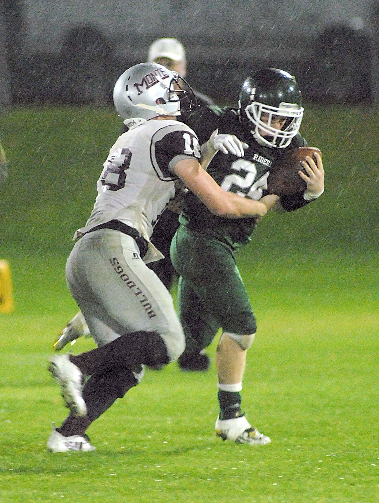 Keith Thorpe/Peninsula Daily News Port Angeles running back Trevor Shumway, right, tries to elude the defense of Montesano’s Shaydon Farmer in second-quarter play on Friday night at Port Angeles Civic Field.