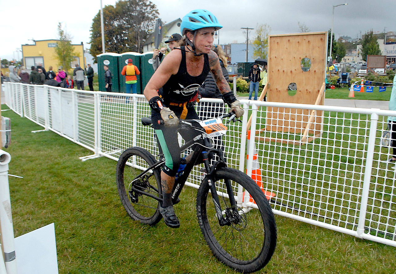 Keith Thorpe/Peninsula Daily News Eliza Winne of the Upper Left Crossfit Sirens team of Sequim finishes the mountain bike leg of the 2018 Big Hurt on Saturday at the West End Park on the Port Angeles waterfront.