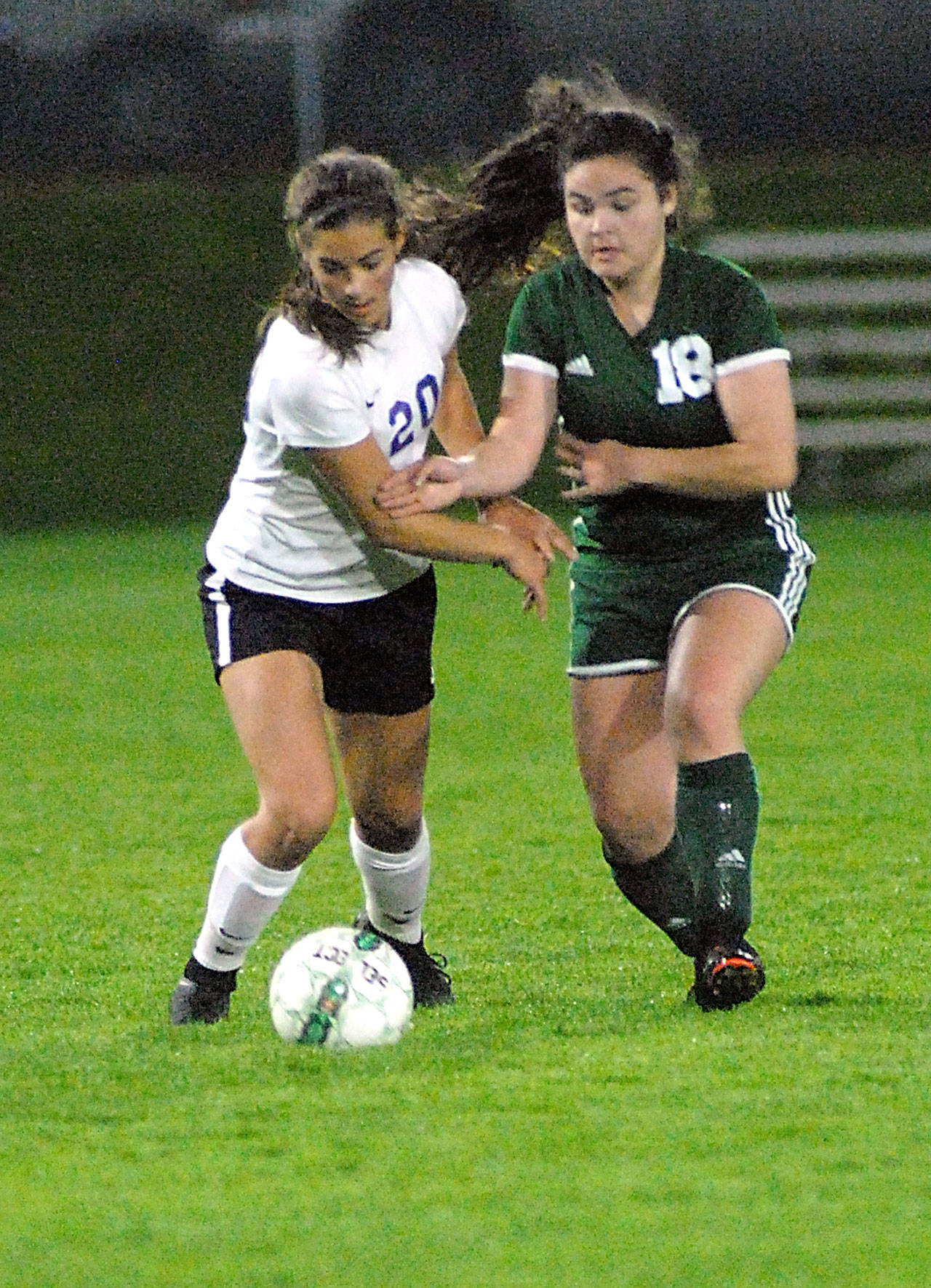 Keith Thorpe/Peninsula Daily News Sequim’s Hope Glasser, left, and Port Angeles’ Kiana Watson-Charles race to the ball during Tuesday night’s match at Port Angeles Civic Field.