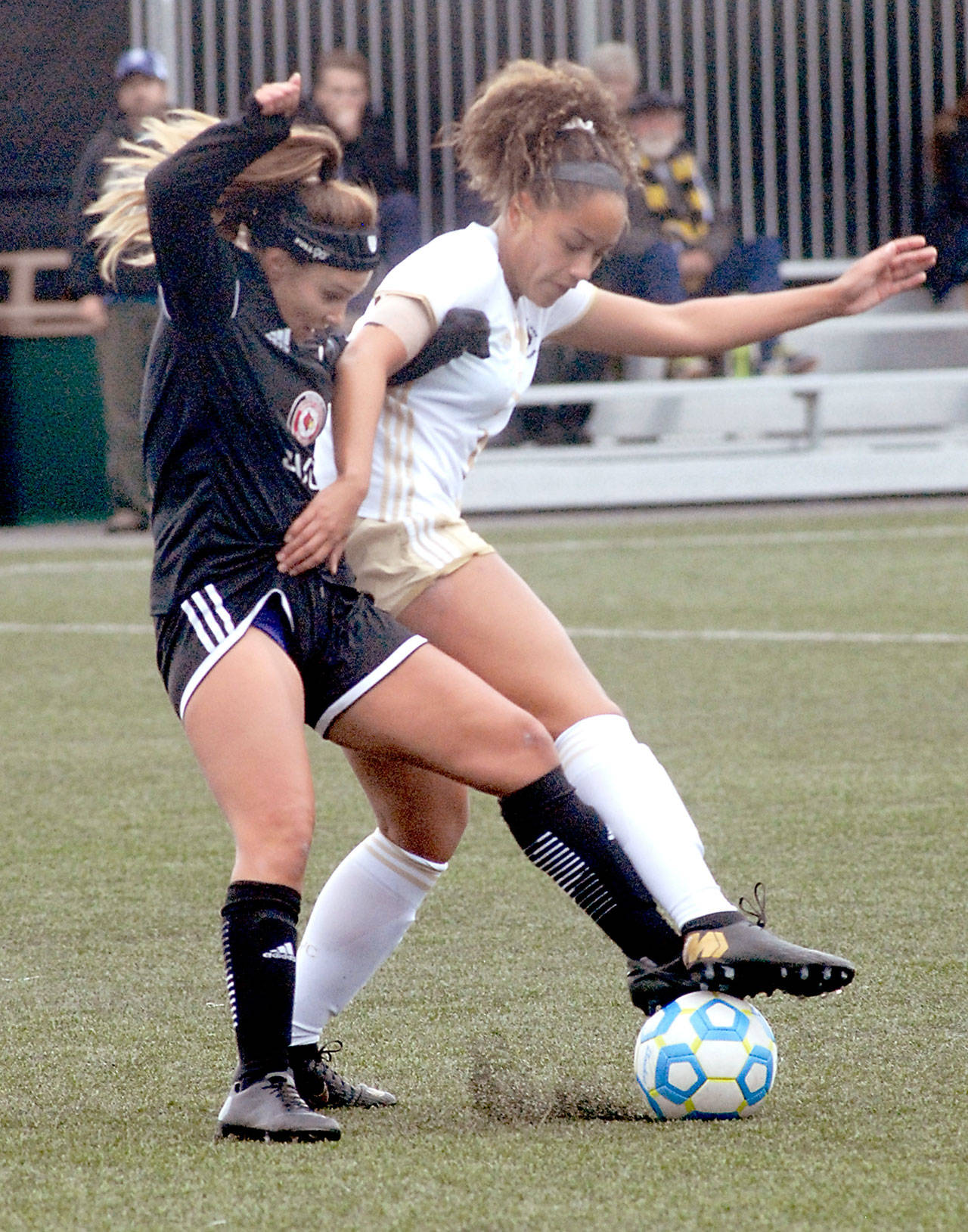 Keith Thorpe/Peninsula Daily News Skagit Valleys Morgan Jones, left and Peninsulas Halle Watson get tangled near midfield on Wednesday at Wally Sigmar Field in Port Angeles.