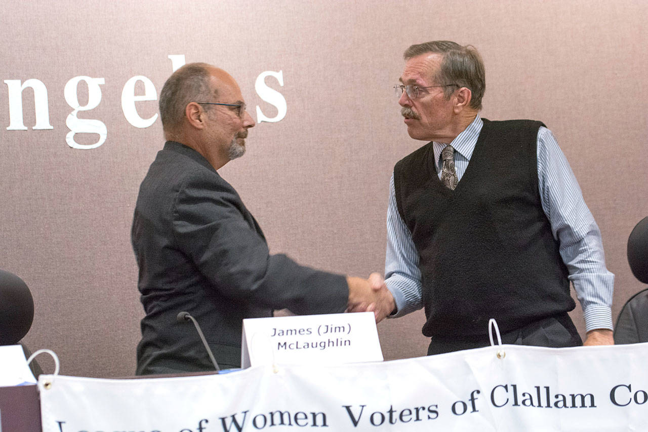 Candidates for Clallam County sheriff Jim McLaughlin, left, and incumbent Bill Benedict shake hands following the League of Women Voters forum Wednesday. (Jesse Major/Peninsula Daily News)