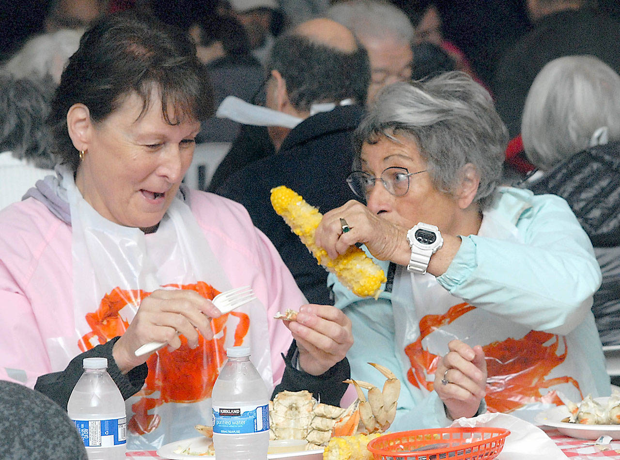 Victoria siblings Melanie Ireland, left, laughs as her sister, Celeste Ireland, waves an ear of corn at her as they dine on a crab dinner Friday at the Dungeness Crab & Seafood Festival in Port Angeles. The three-day event, which continues today, was expected to draw thousands of festival-goers, including hundreds from Canada. (Keith Thorpe/Peninsula Daily News)