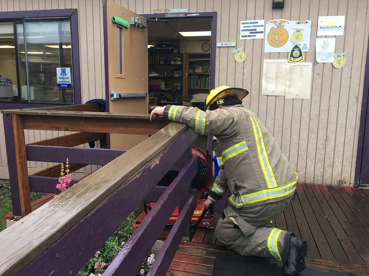 Firefighters with Clallam County Fire District 3 place fans outside this portable classroom at Sequim High School after a faulty heater started to smoke Friday. (Matthew Nash/Olympic Peninsula News Group)