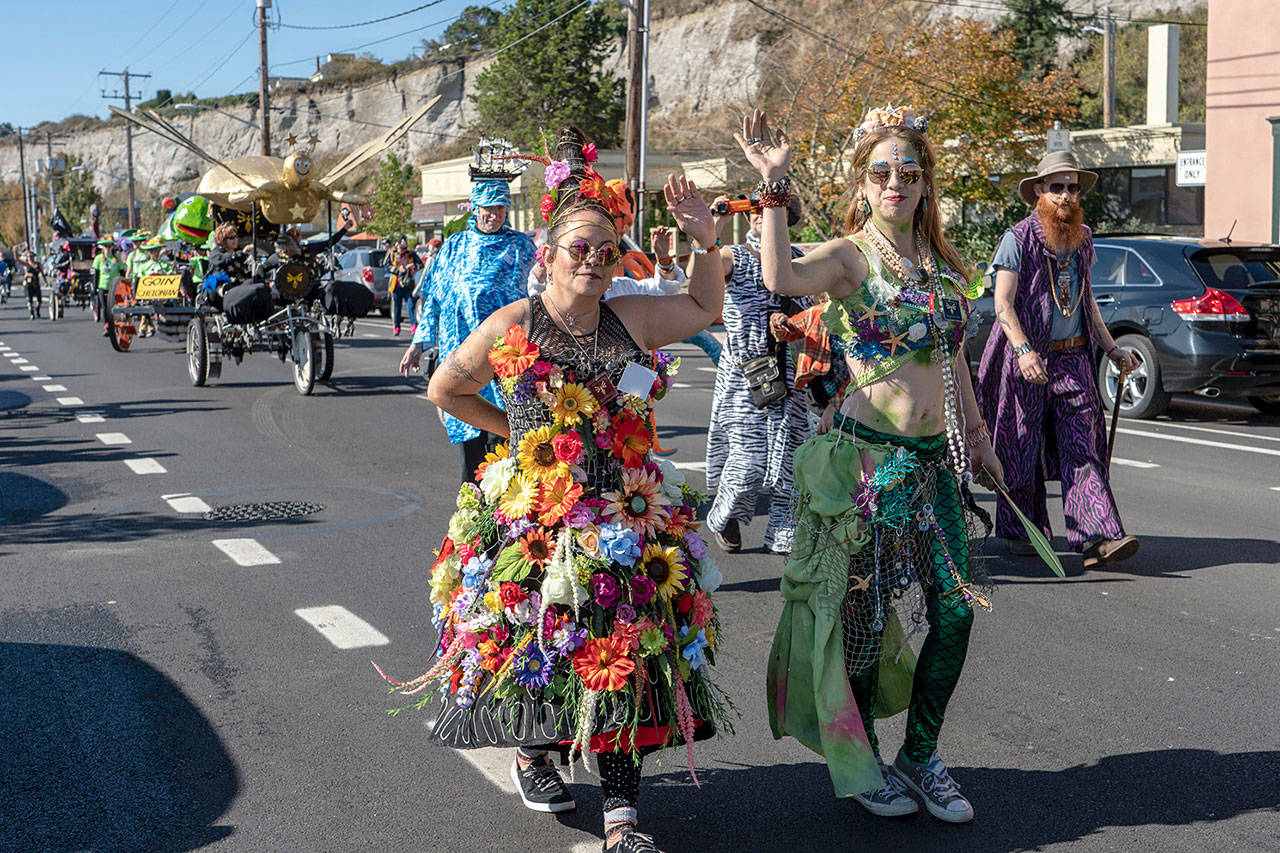 Selena Espinoza, left, and her daughter Serita march down Water Street at the start of the 36th Kinetic Skulpture parade in Port Townsend on Saturday. Selena is the emcee for the Kinetic Race, which takes place today and Serita vied for the title of Rose Hips Kween during the ball Saturday night. (Steve Mullensky/for Peninsula Daily News)