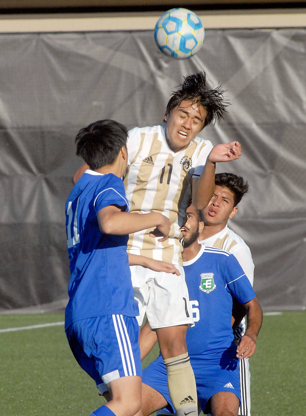 Keith Thorpe/Peninsula Daily News                                Peninsula’s Calvin Aguirre, center, takes the header surrounded by Edmonds’ Masahiro Ichikawa, left, and Rafaiel Dawood on Wednesday in Port Angeles. Backing the play was Peninsula’s Manny Lopez, right.