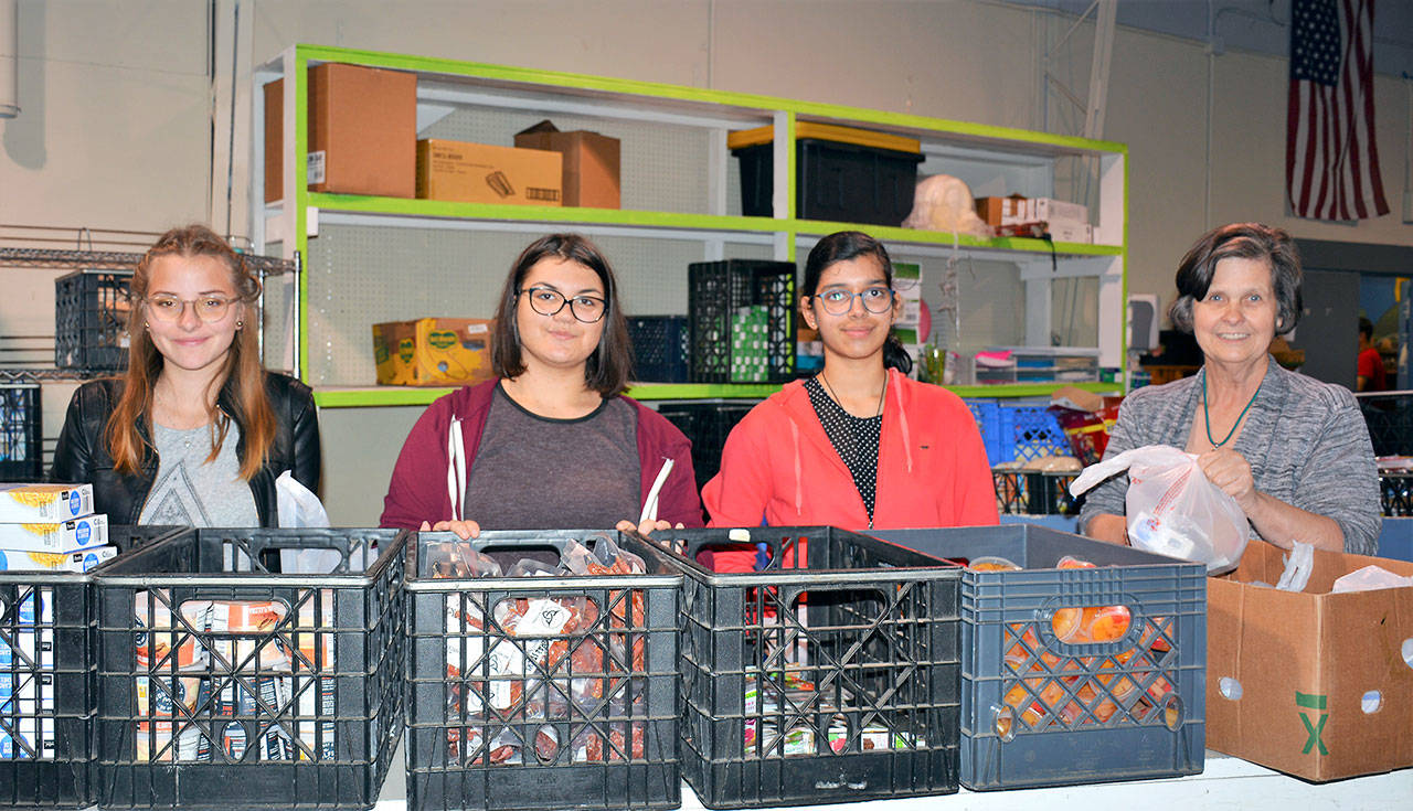 Connie Panike, far right, local coordinator for American Councils, and helpers prepare Friday Food Bags at the food bank for students in Port Angeles schools. The students are, from left, Sindija Bahmane of Latvia, Marija Arsovska of Macedonia and Fatima Bandukwala of India. They are all exchange students attending Port Angeles High School. (Patsene Dashiell/Port Angeles School District)