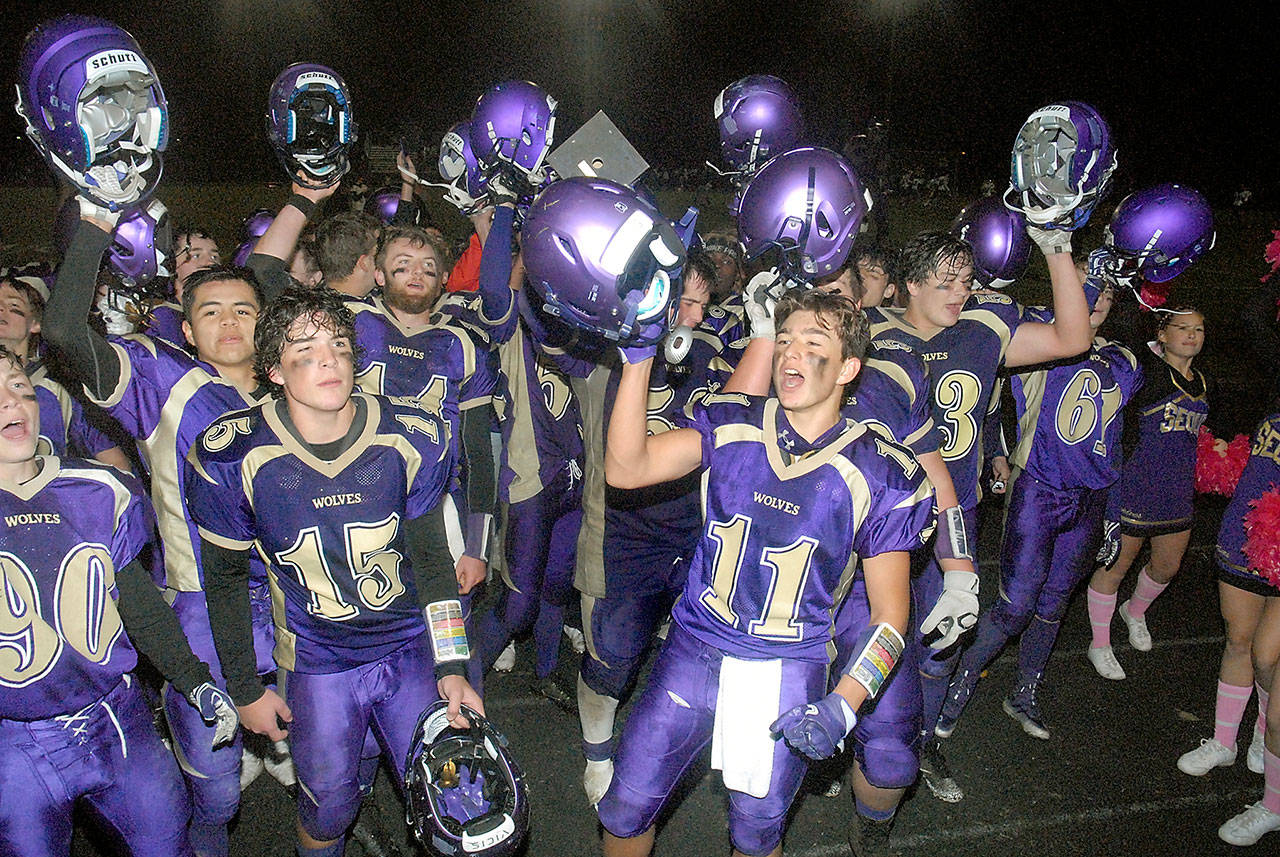 Keith Thorpe/Peninsula Daily News Members of the Sequim High School football team raise their helmets in jubilation after Friday night’s 46-6 win over Port Angeles in Sequim.