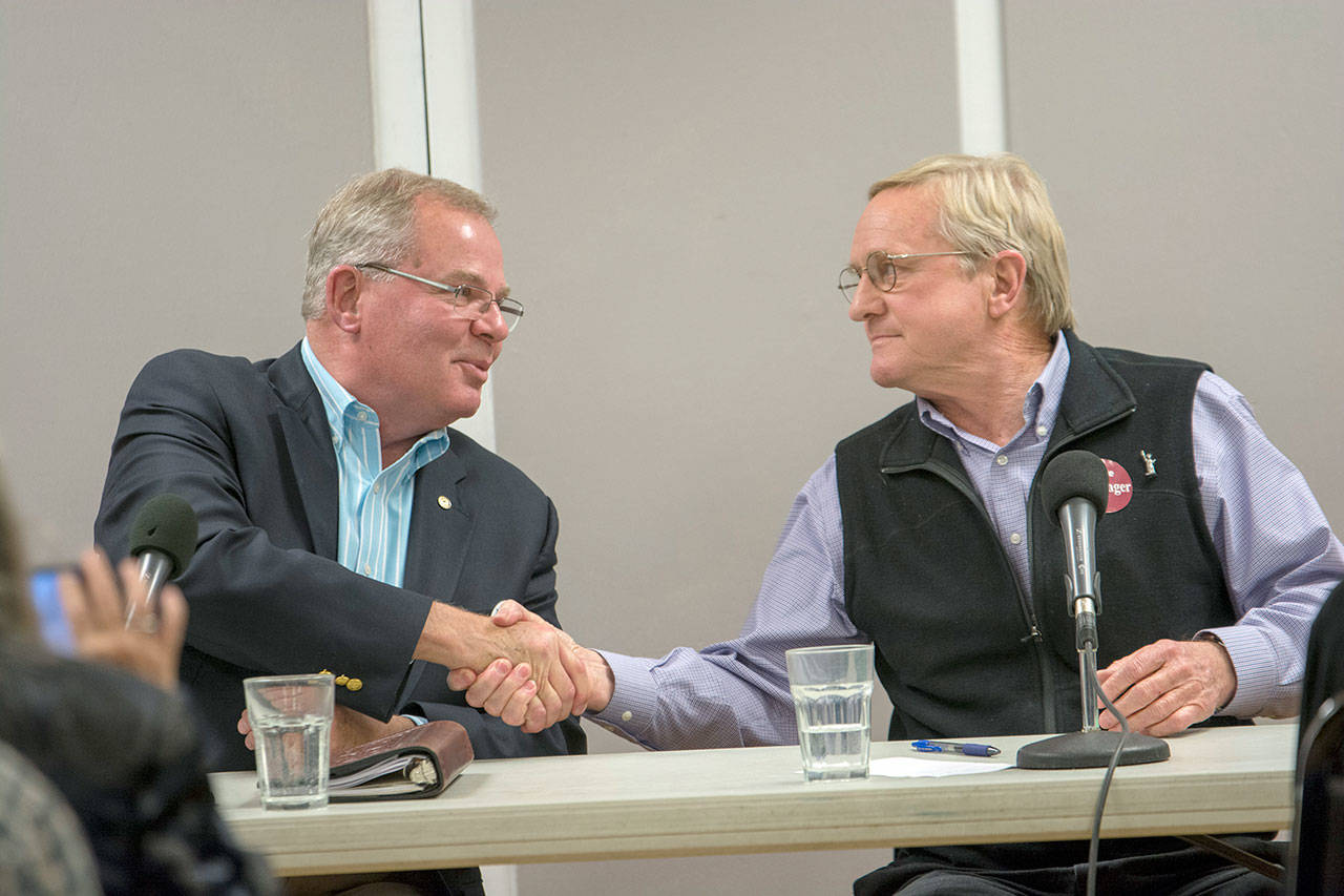Republican Jim McEntire, left, shakes hands with incumbent state Rep. Steve Tharinger, a Democrat, during a forum in Chimacum on Tuesday night. (Jesse Major/Peninsula Daily News)