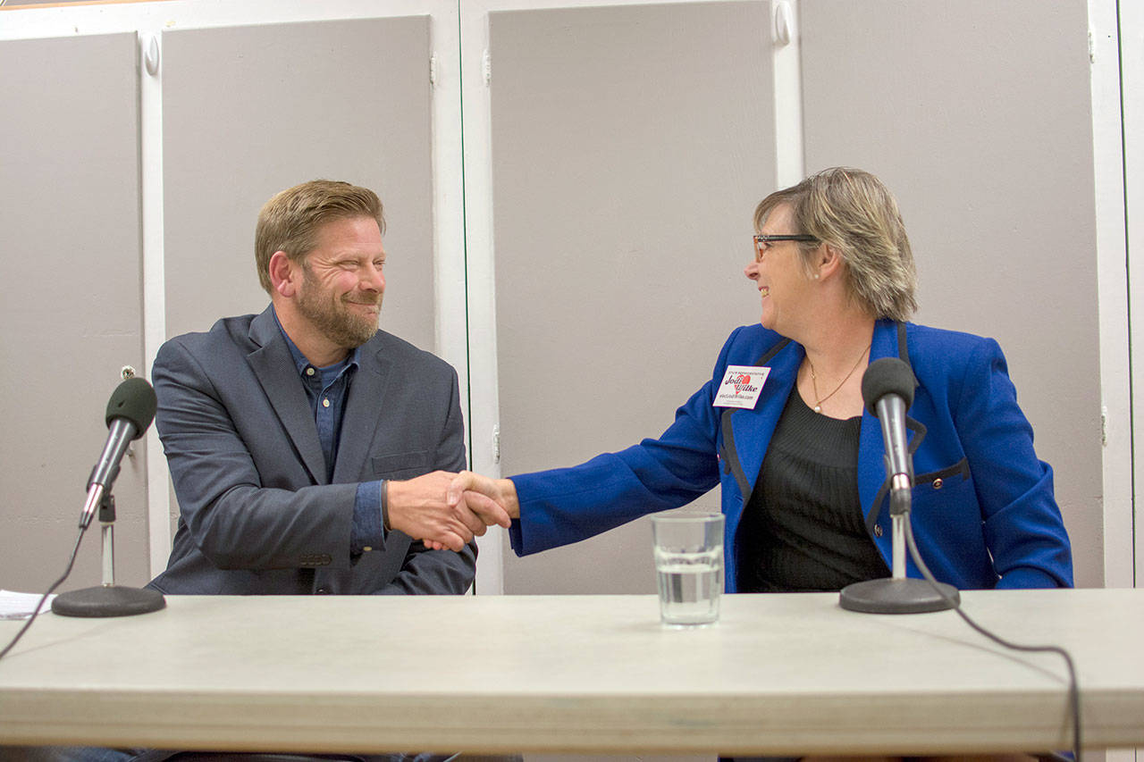 Incumbent Rep. Mike Chapman, a Democrat, shakes hands with Republican challenger Jodi Wilke after a candidate forum in Chimacum on Tuesday night. (Jesse Major/Peninsula Daily News)