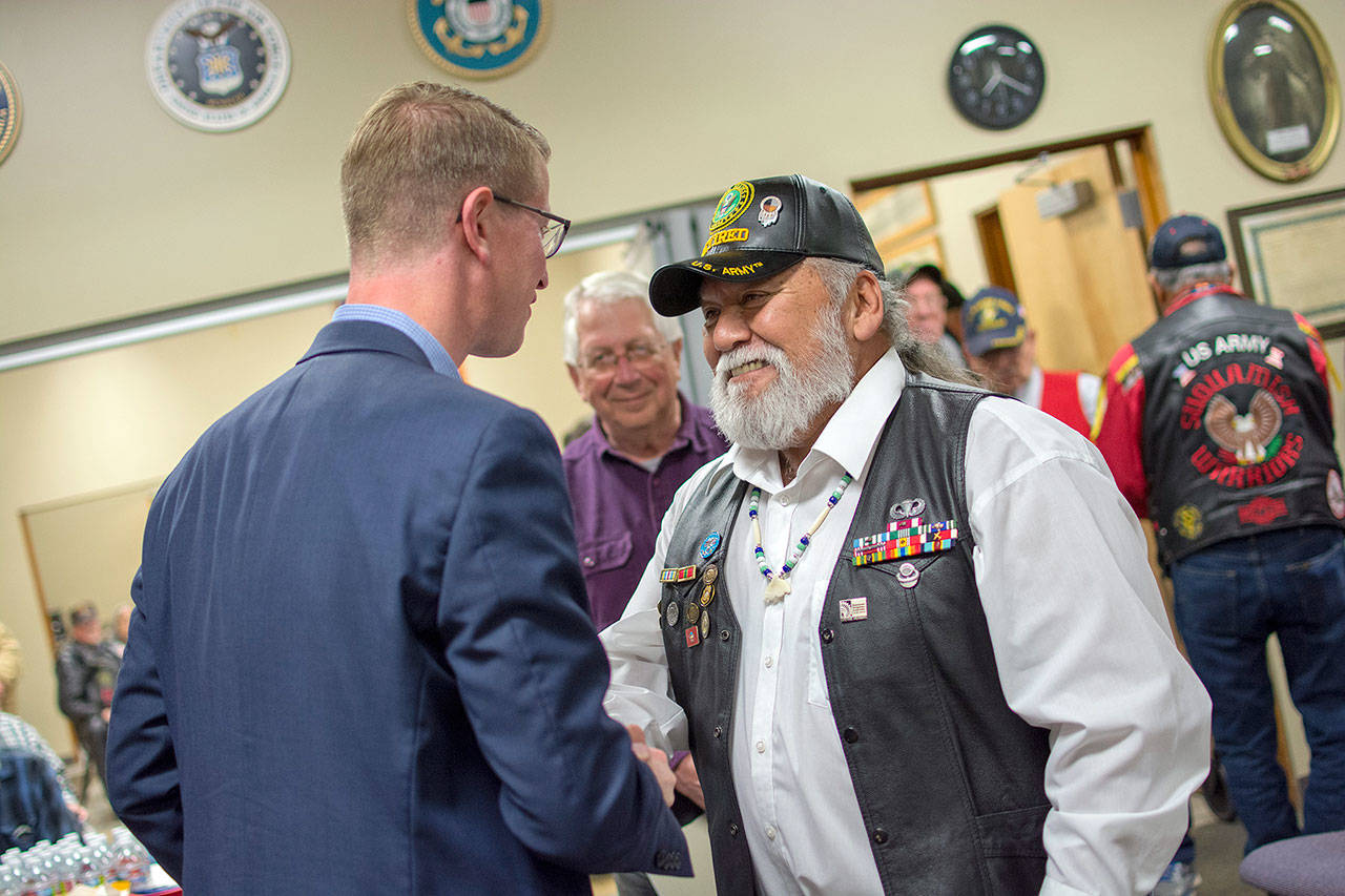 U.S. Rep. Derek Kilmer, left, shakes hands with Army veteran Joe Turrey during a community pinning ceremony honoring veterans who served during the the Vietnam War era at the Northwest Veteran Resource Center in Port Angeles. (Jesse Major/Peninsula Daily News)