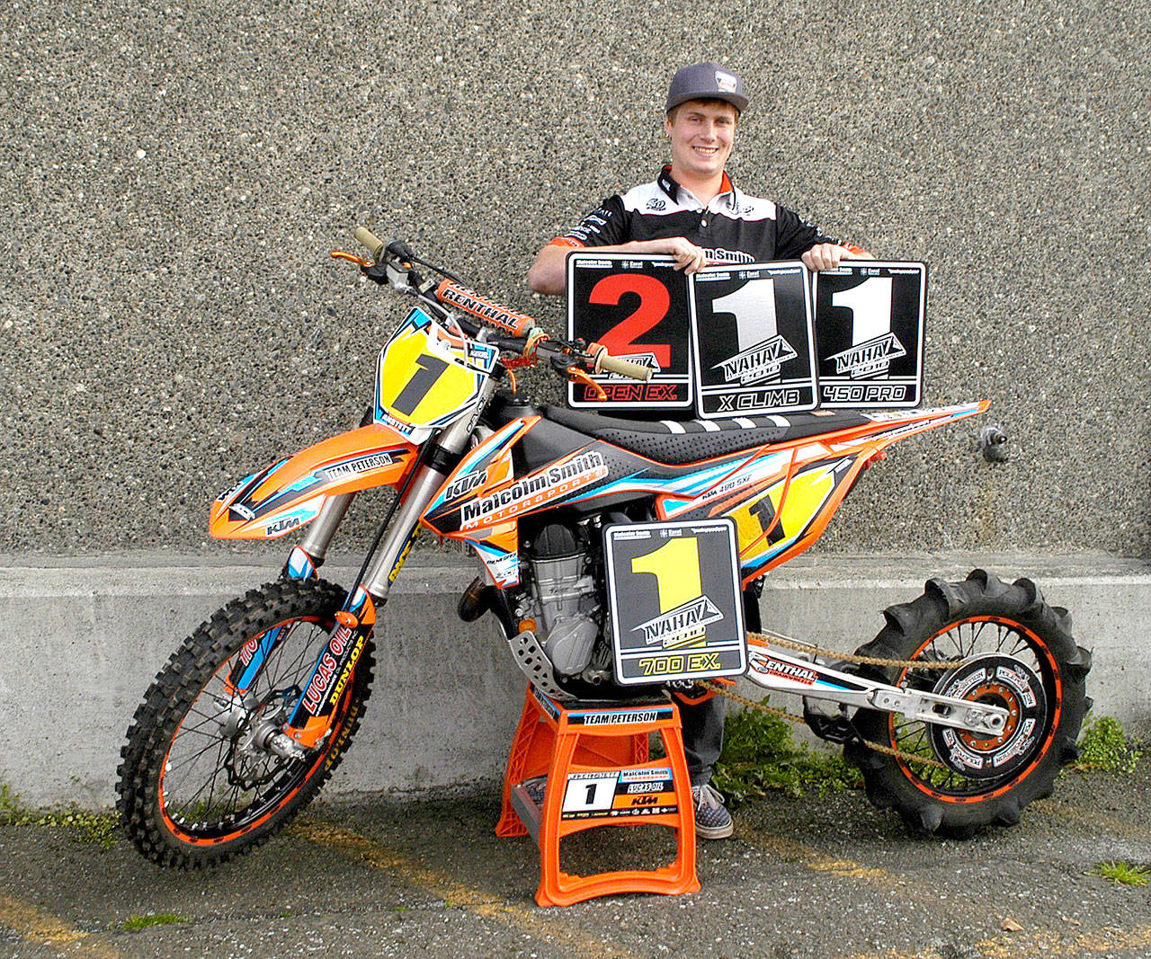 Port Angeles’ Jake Anstett with one of his uphill motorcycles and several of the trophies he has won this year hill climbing. Anstett was named the North American Hillclimbers Association Rider of the Year in 2018. (Pierre LaBossiere/Peninsula Daily News)