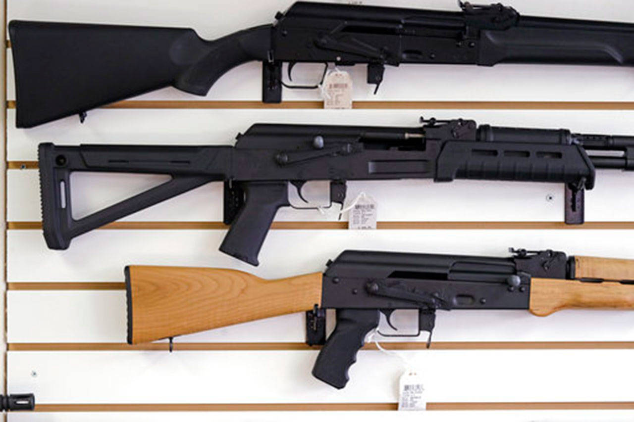 Semi-automatic rifles are displayed on a wall at a gun shop in Lynnwood. Voters will decide the fate of I-1639 in the Nov. 6 election. (The Associated Press)