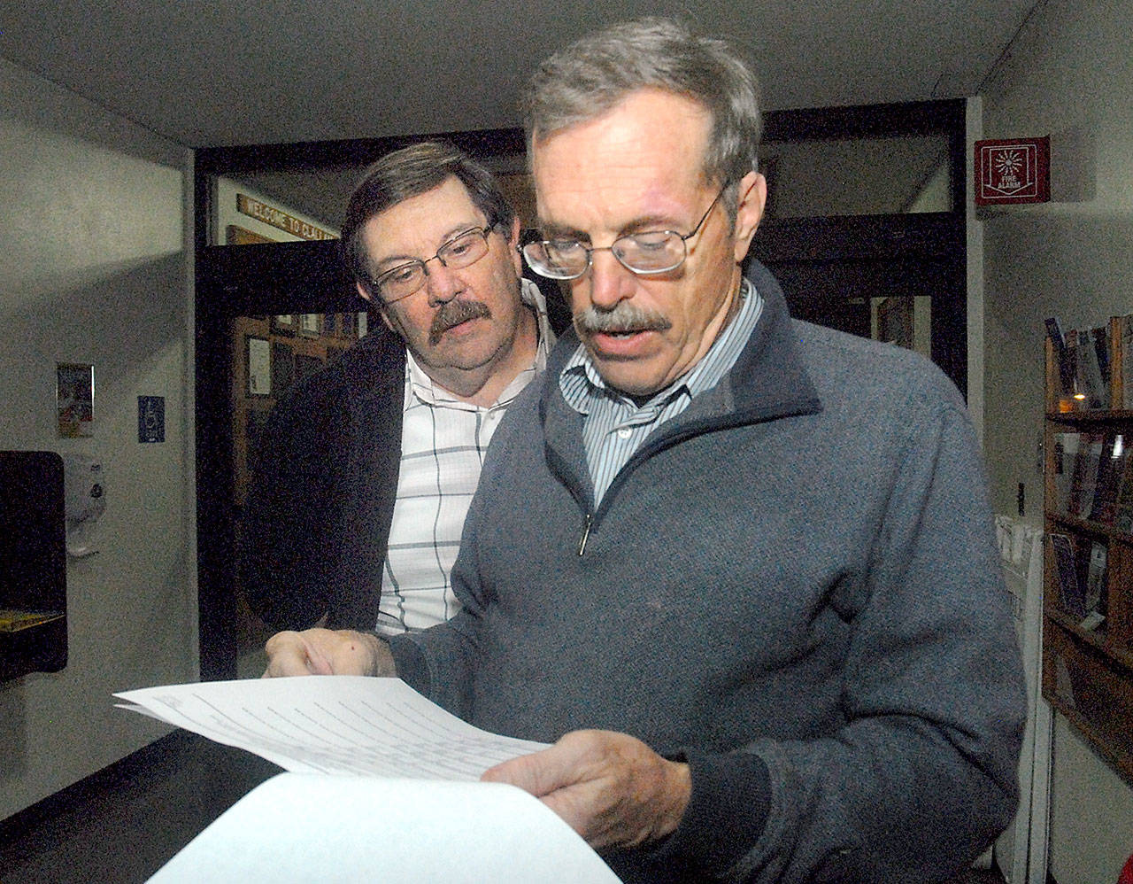 Clallam County Sheriff Bill Benedict looks at election returns as Undersheriff Ron Cameron looks over his shoulder at the Clallam County Courthouse on Tuesday night. (Keith Thorpe/Peninsula Daily News)