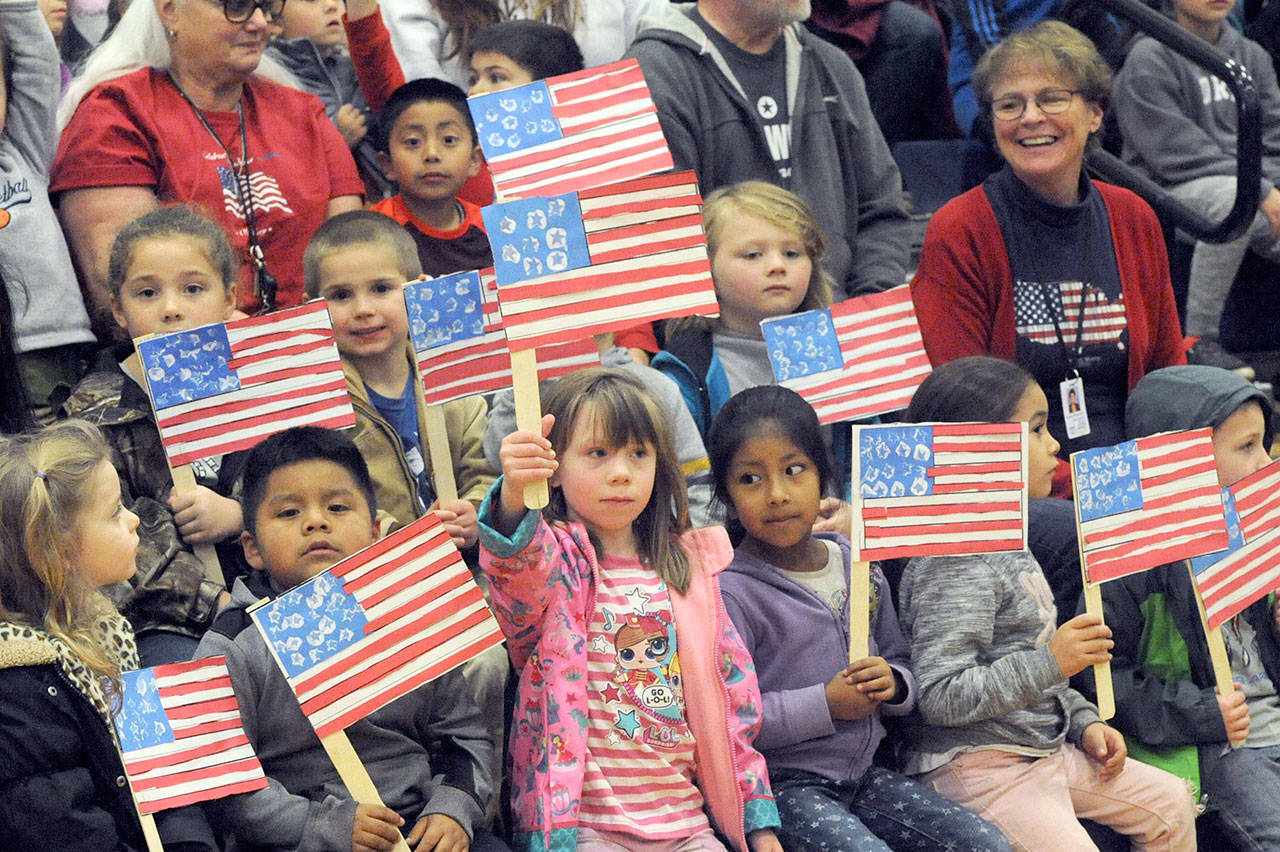 Forks kindergarten students display the colors during the Quillayute Valley School Districts Veterans Day Assembly on Friday afternoon in the Spartan gym. Their teacher, seen to the right, is Karen Wittenborn. Several student speakers, songs, the Quileute Tribe drummers, award presentations, the U.S. Coast Guard color guard school bands honored the many veterans who gathered for the assembly. (Lonnie Archibald/for Peninsula Daily News)