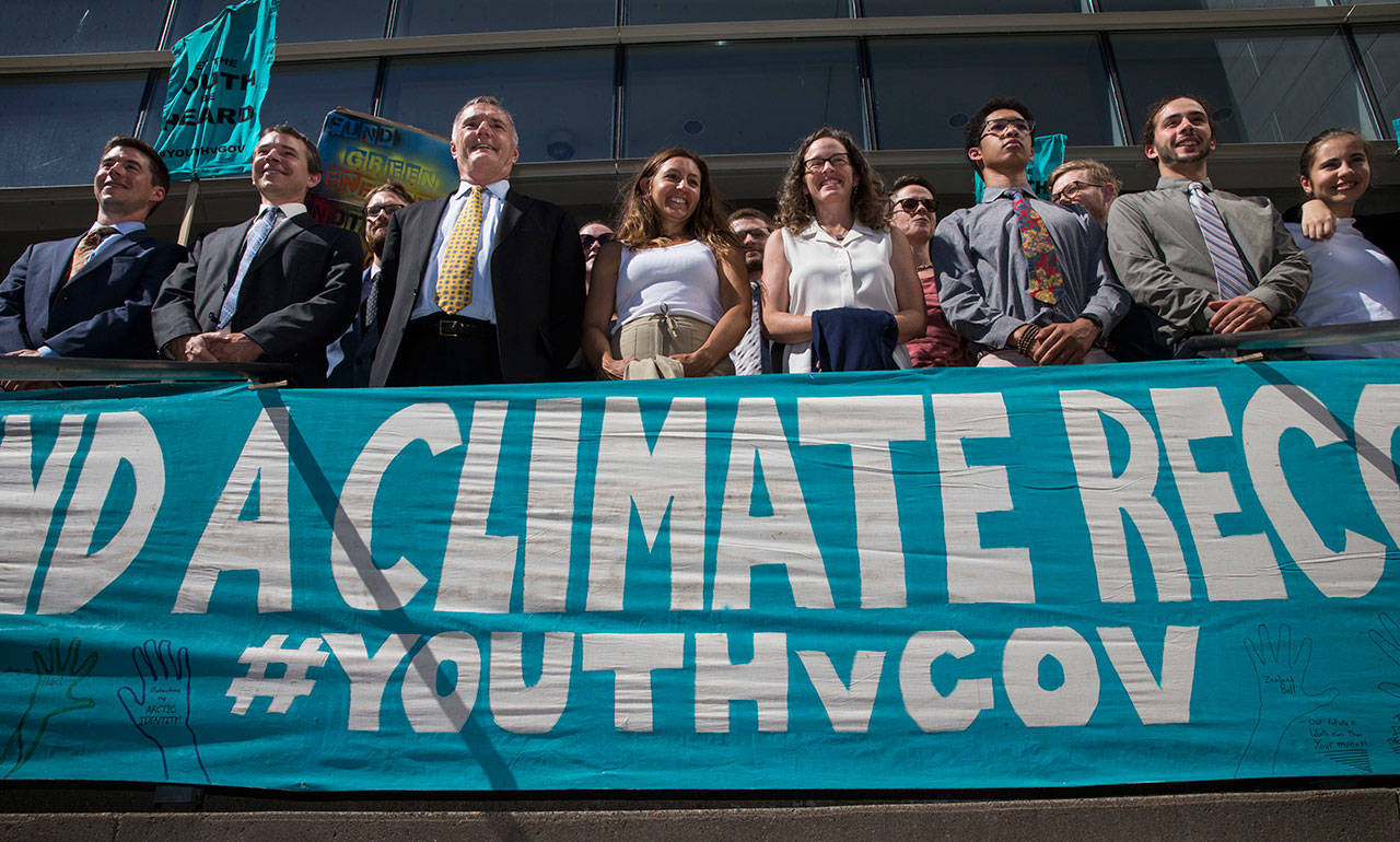 In this July 18, file photo lawyers and youth plaintiffs line up behind a banner after a hearing before Federal District Court Judge Ann Aiken between lawyers for the Trump Administration and the so called Climate Kids in Federal Court in Eugene, Ore. (Chris Pietsch/The Register-Guard via AP)